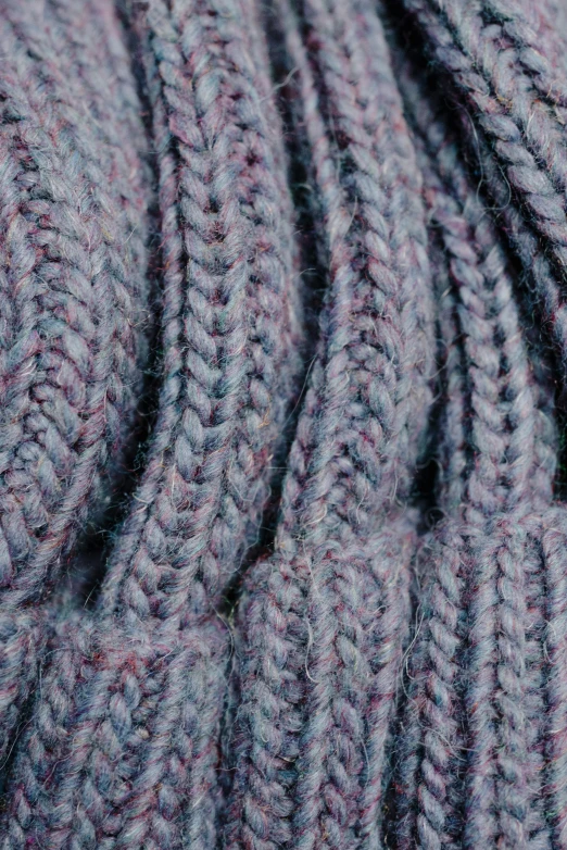 a close up s of the purple yarn on the knitting machine