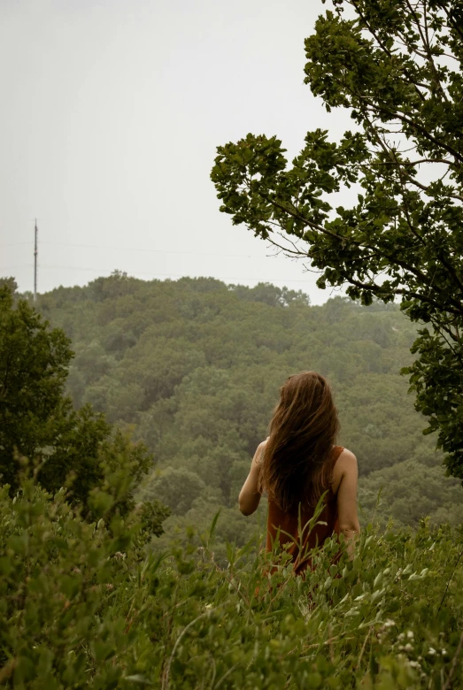 a woman with her back turned is in the grass