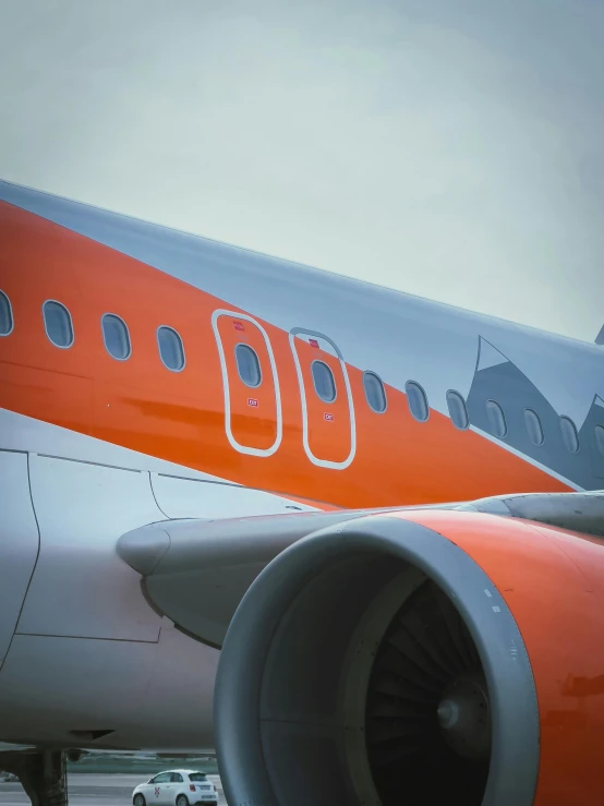 an orange airplane is on the runway, closeup