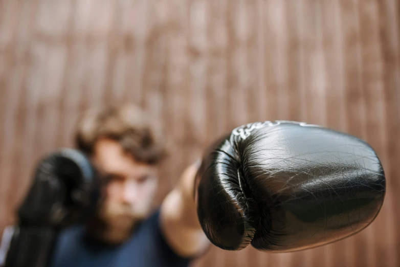 a man is wearing a black boxing glove