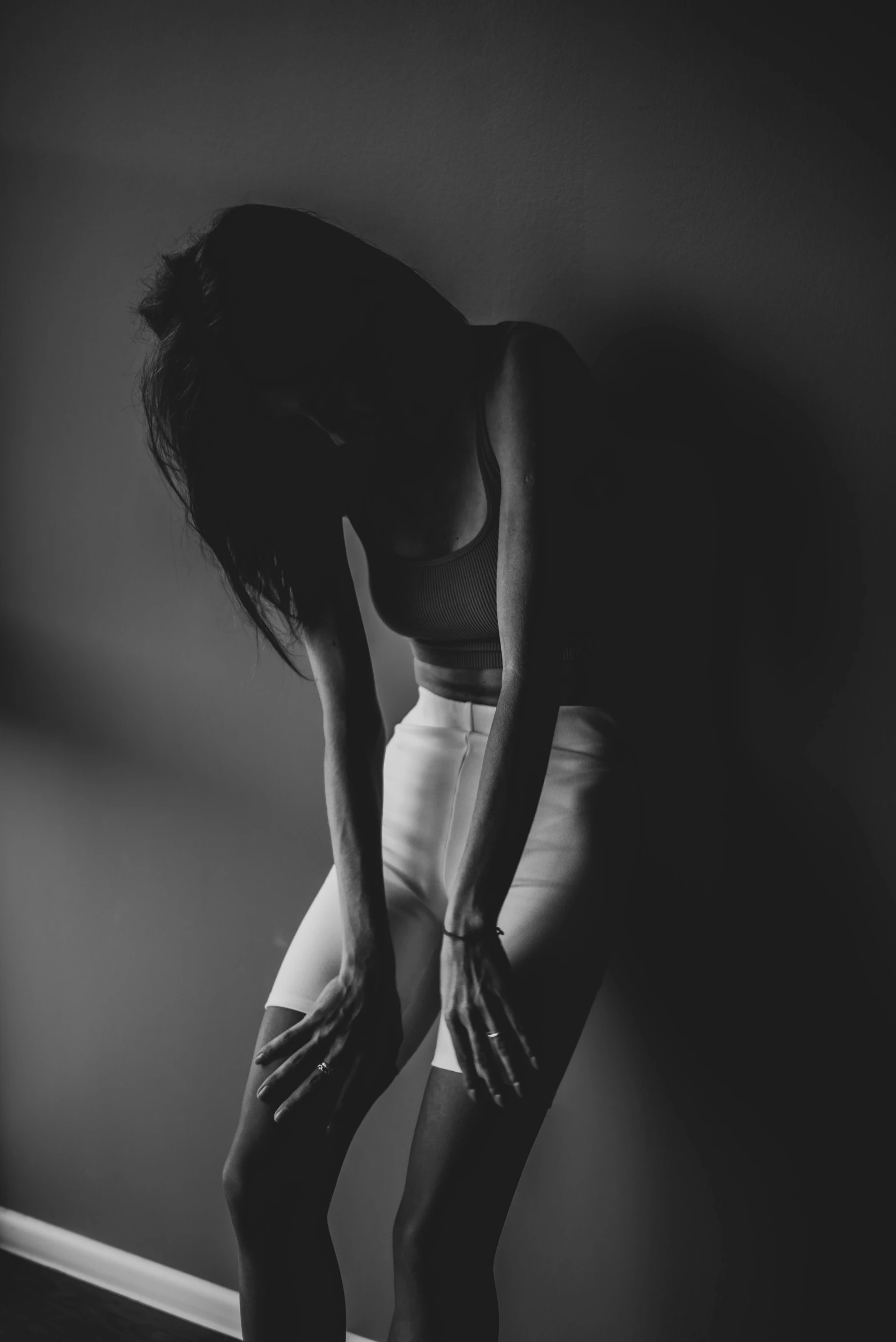 a woman is kneeling on the floor holding her hands behind her back