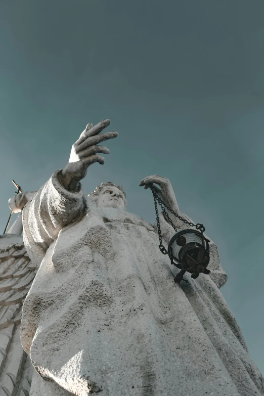 a statue has its hands spread out towards another statue