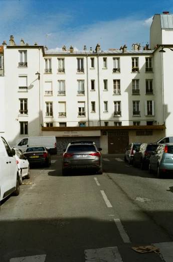 several cars parked in front of a white building