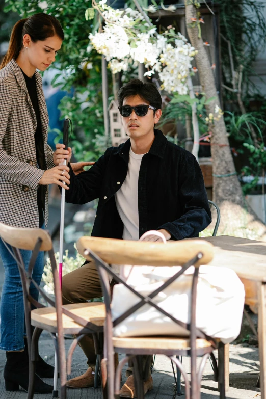 a young man holding an umbrella on top of a sidewalk