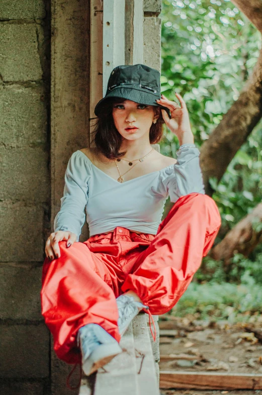 a woman sitting on a wooden plank next to trees