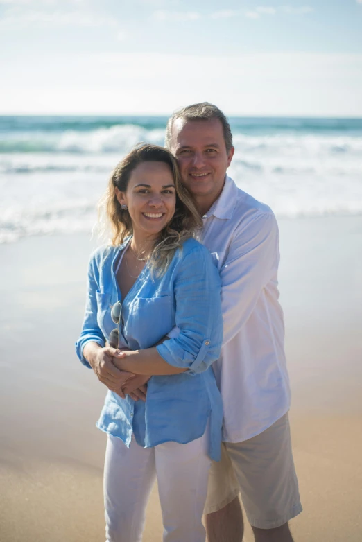 an older couple smiling for a po at the beach