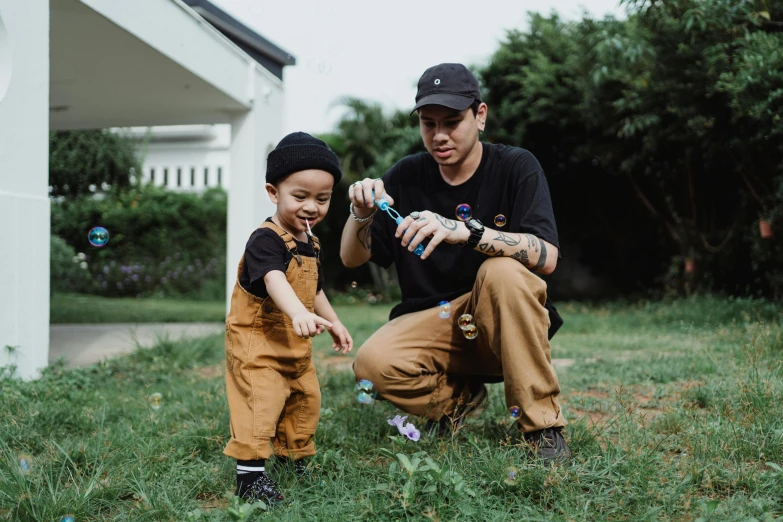 a father and son playing outside on the grass