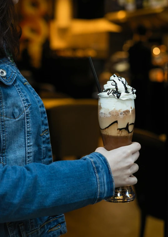 a woman holds a drink in a glass