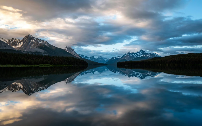 mountains are reflected in the still waters of a lake