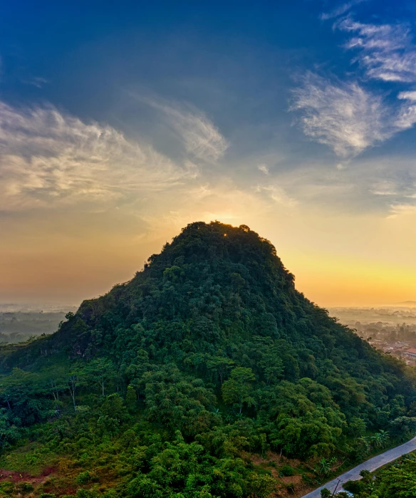 a view of the sun setting over a hill