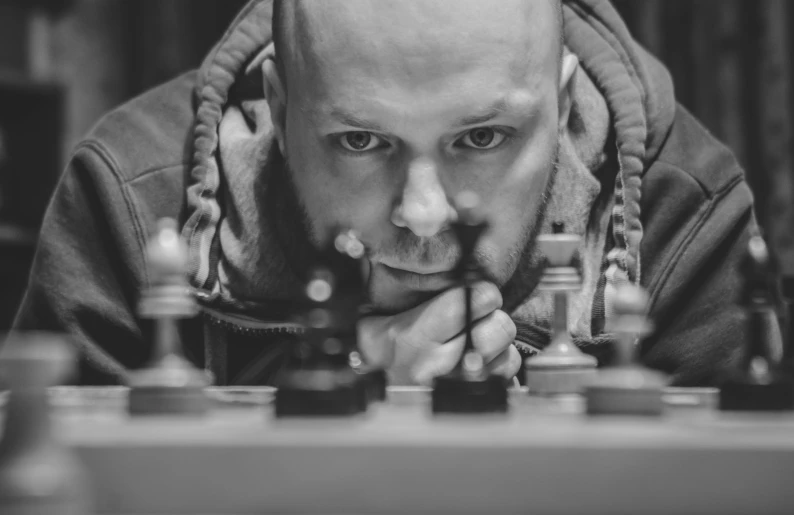 a man looking over a chess board at the camera