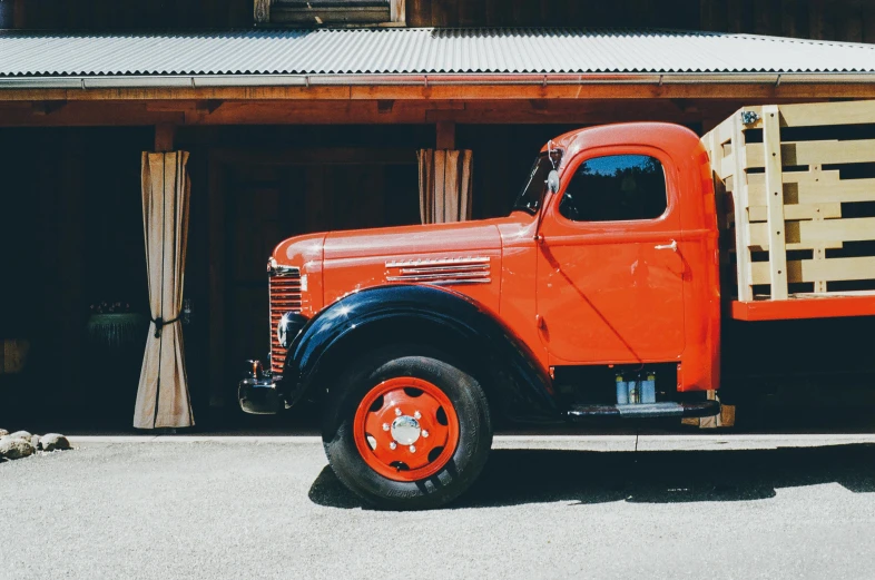 a red truck parked outside of a wooden building