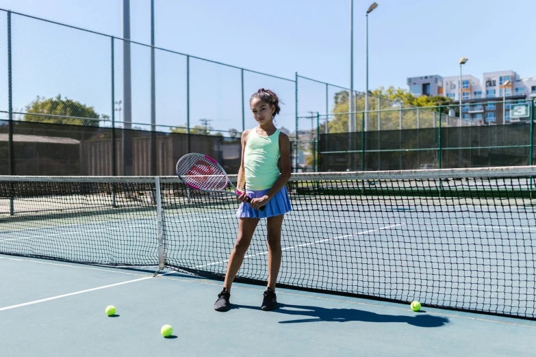 a young woman poses for the camera on a tennis court