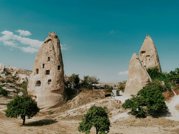 a group of trees in front of many rock formations