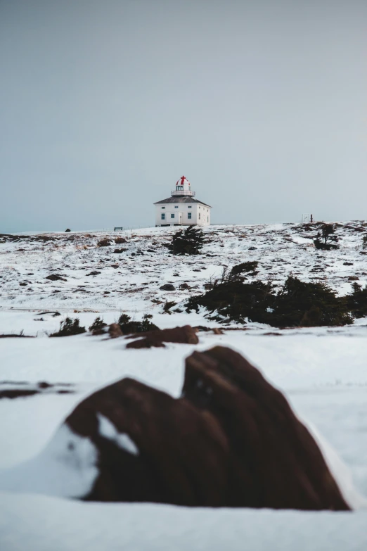 a snow covered mountain with a light house on top of it