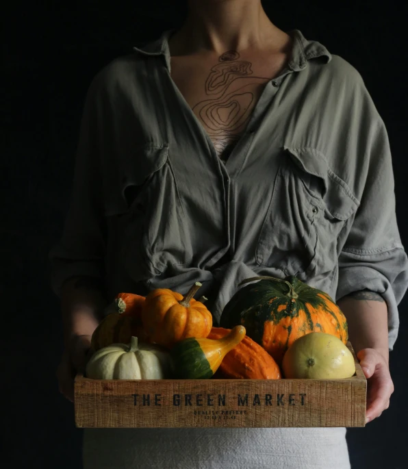 the man is holding a wooden crate of fruit