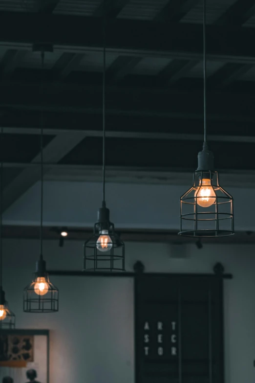 an industrial lighting fixture hangs from the ceiling above a counter