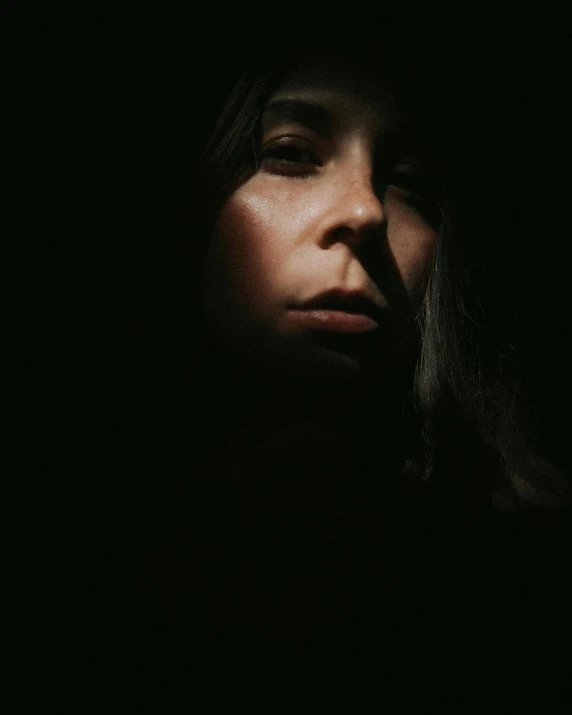 a woman in the dark looking into her hand