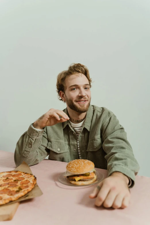 a man sitting at a table with two sandwiches in front of him