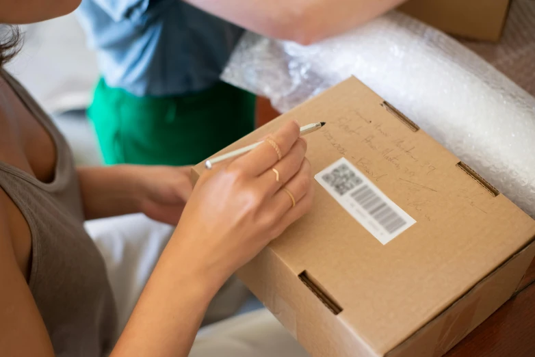 woman opening up a cardboard box with a barcode on it