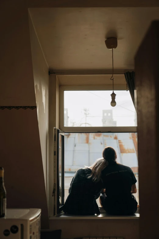 two people looking out of a window at construction