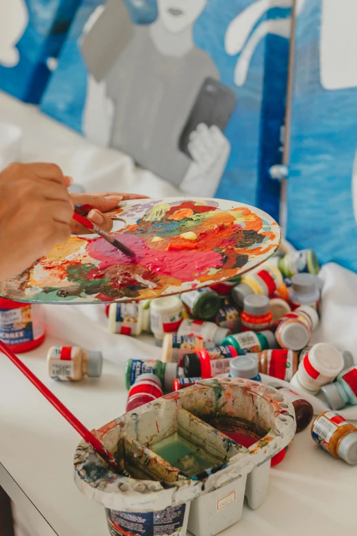 someone painting an artistic piece of art with watercolors and acrylic paint