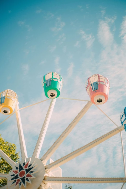 colorful ferris wheel against a blue sky with clouds