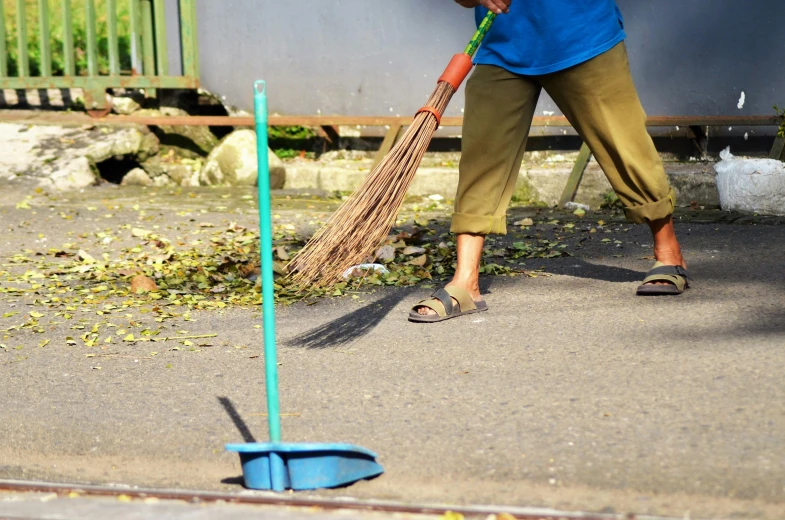 a person sweeping the street on a broom