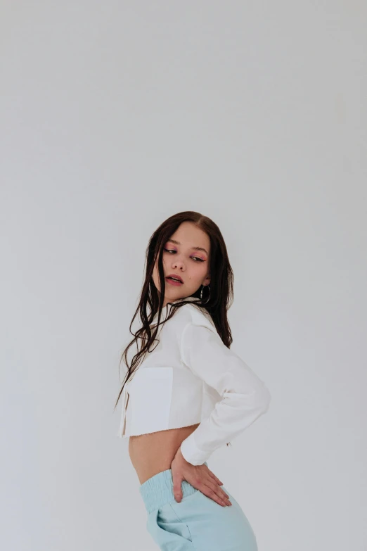 woman looking at herself while standing in a white room