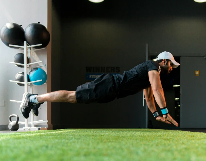 a man is doing an exercise in a green floor