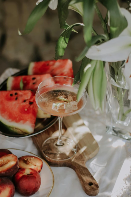 a glass and some peach slices with wine