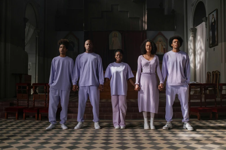 four people posing for the camera while wearing purple pajamas