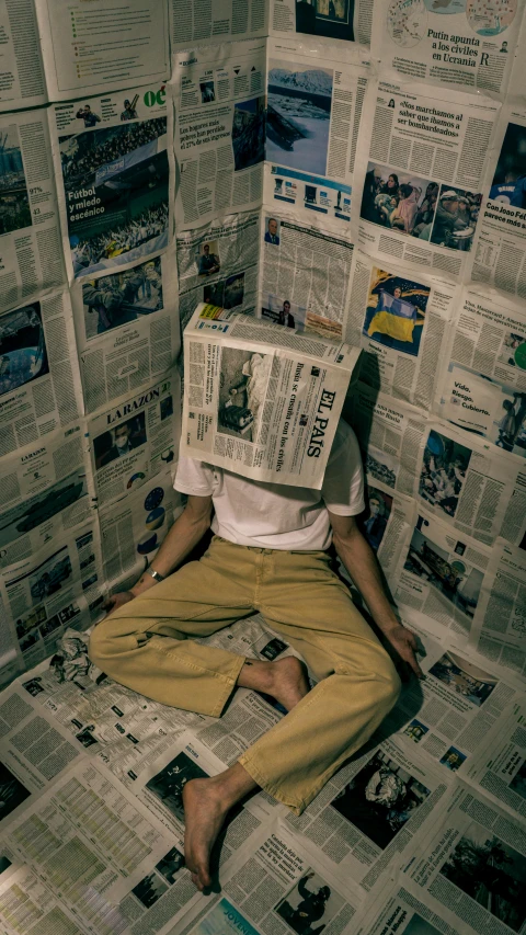 a person is sitting on top of a newspaper