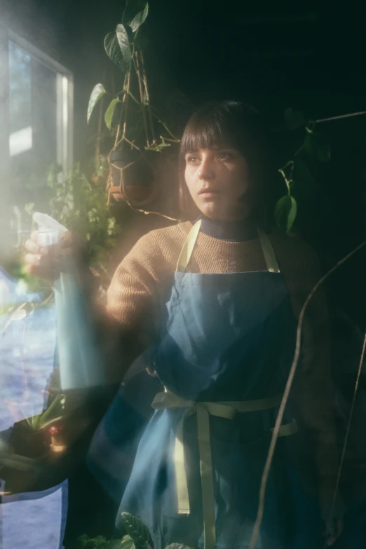 a man holding a watering hose over some plants