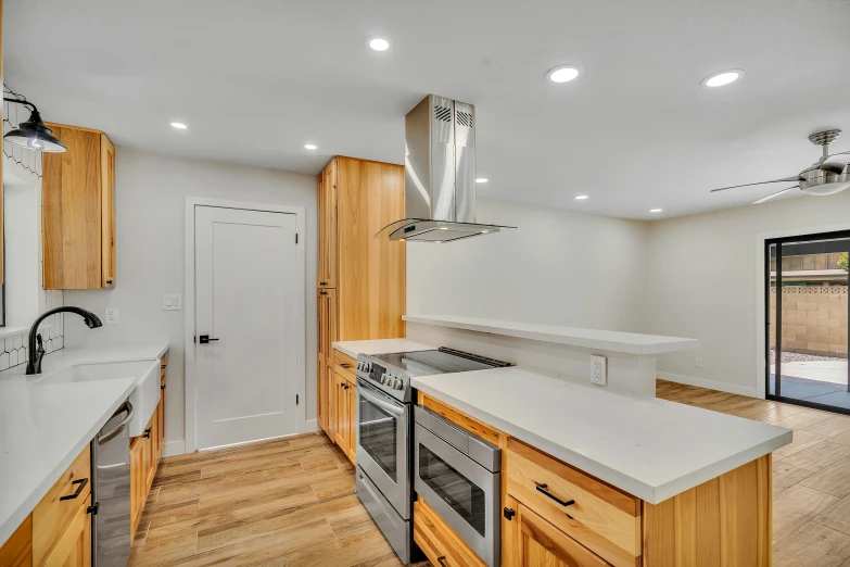 a kitchen with white counters and wood cabinets