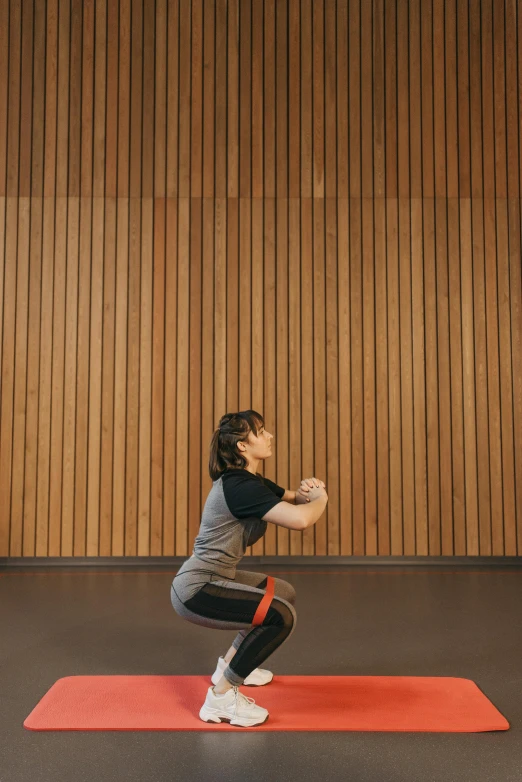 the woman in gray shirt is practicing lung exercises