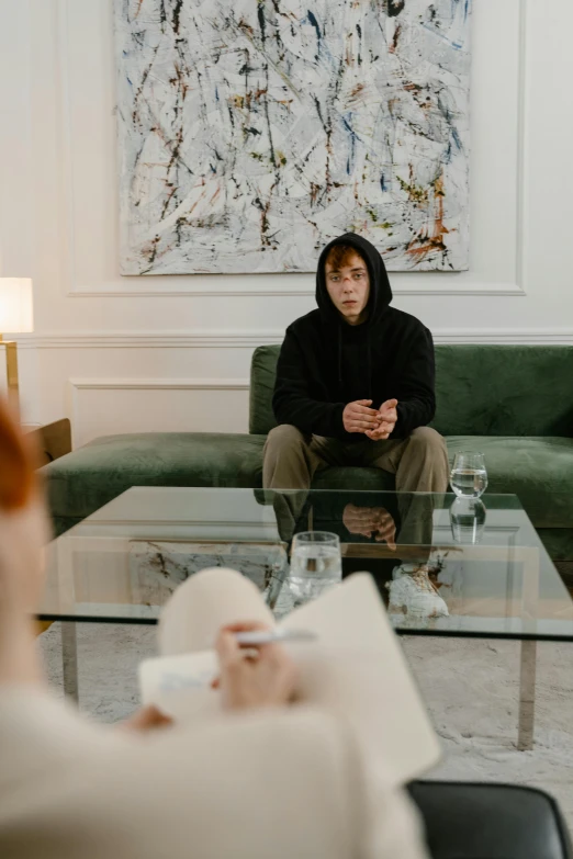 a man sitting on top of a couch next to a coffee table