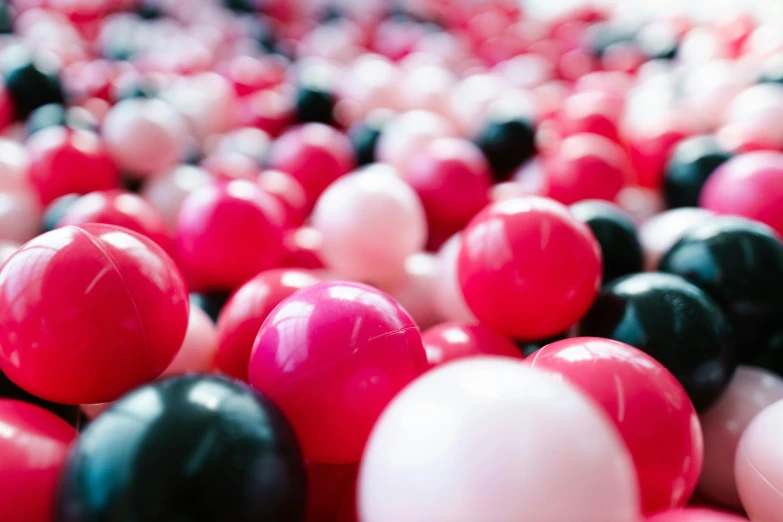 there are many red and black balloons on the ground