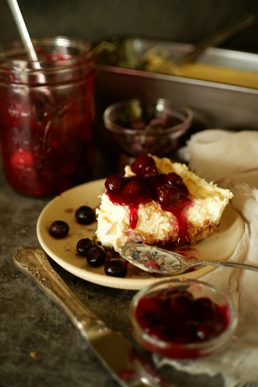 a slice of cheesecake sitting on top of a plate next to jelly