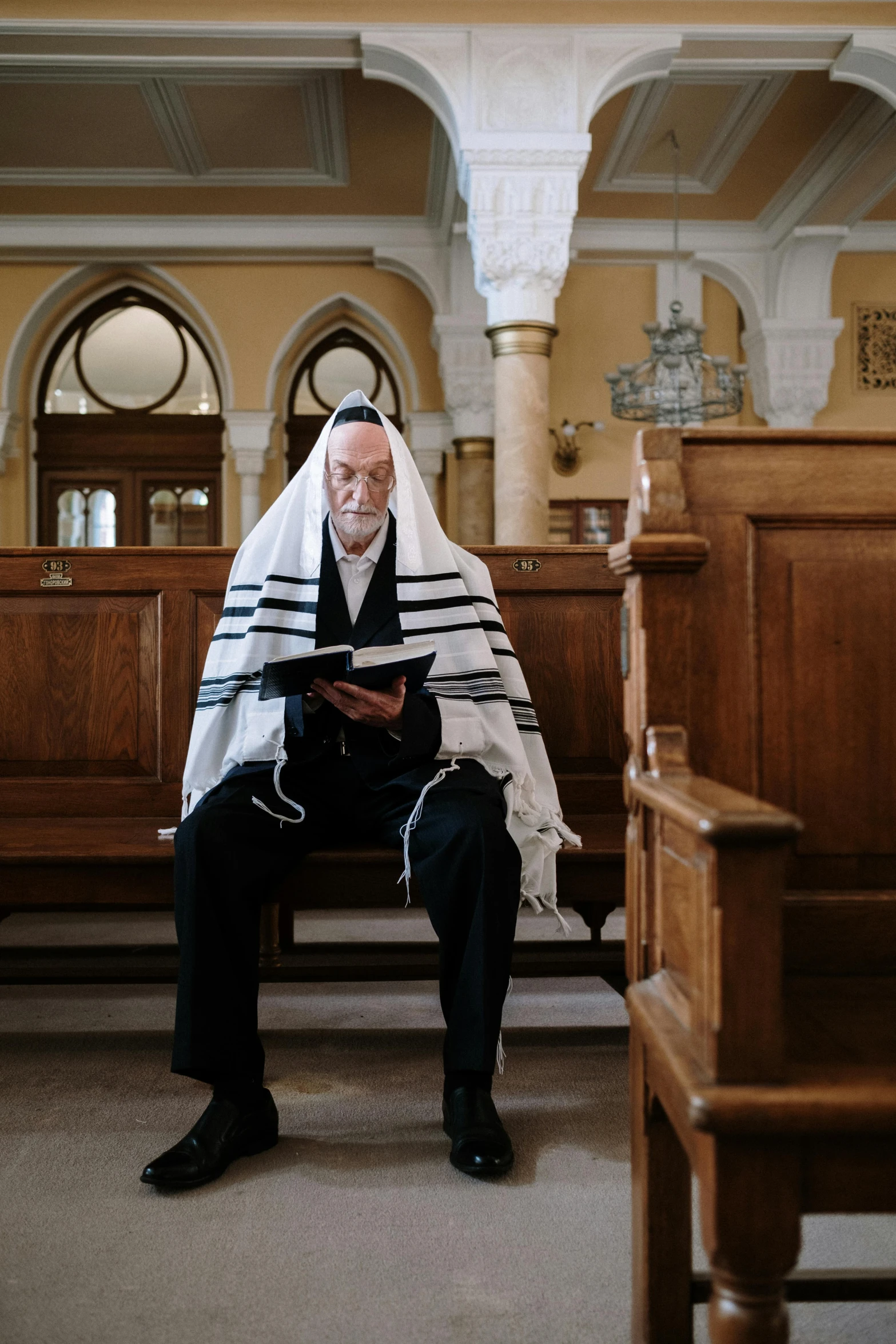 a man reading while sitting on a wooden bench