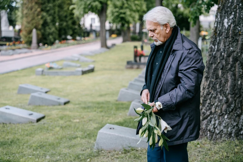 an older man is standing near some graves