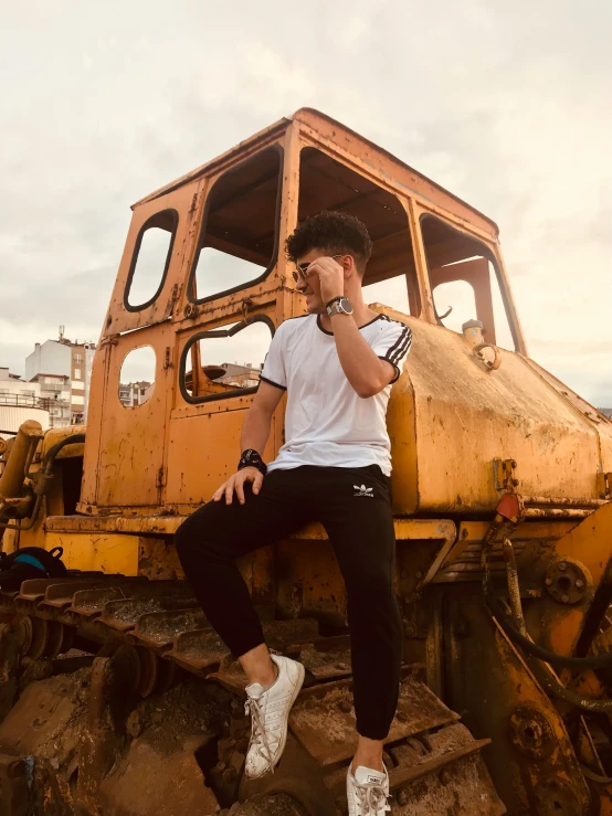 a guy is sitting on top of an old tractor