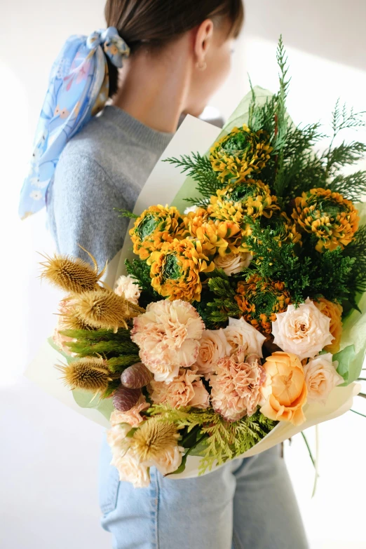 the young woman has a large bouquet of flowers on her shoulder