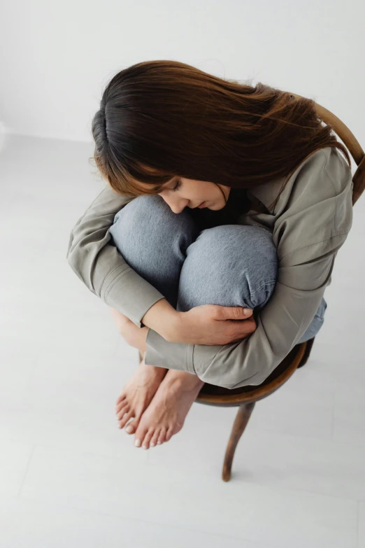 the woman is laying on her lap, clutching a pillow