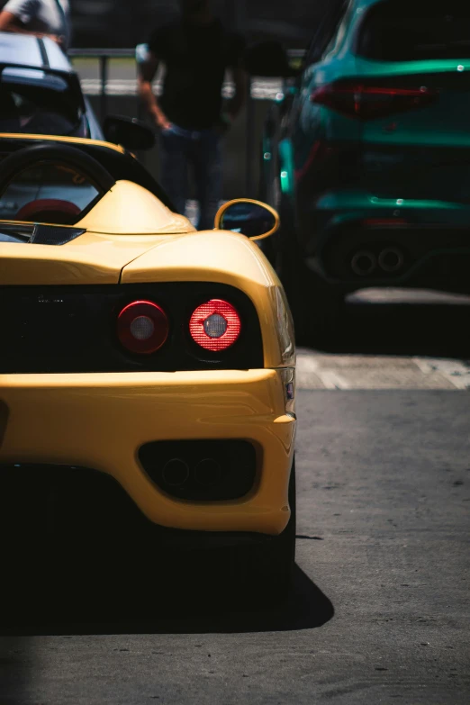 the rear end of a sports car that is parked on the side of a street