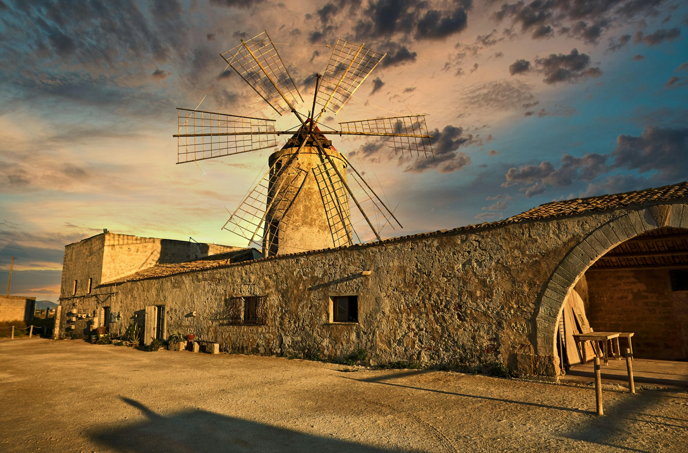 a very big pretty windmill by some old buildings