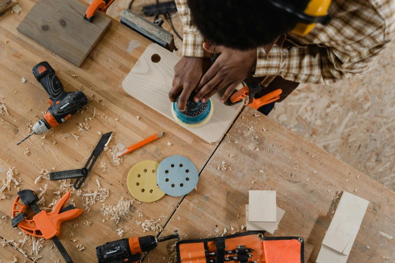 a person is holding a tool and some power tools on a table