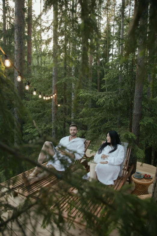 two people in robes sitting on wooden deck