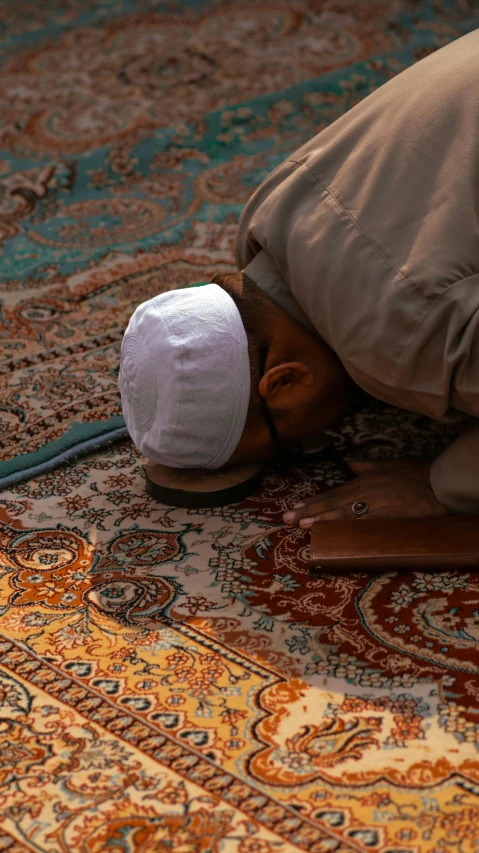 an elderly man wearing a headscarf on the carpet