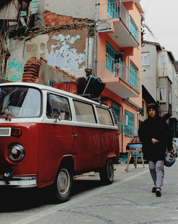 a person walks by an old red and white van